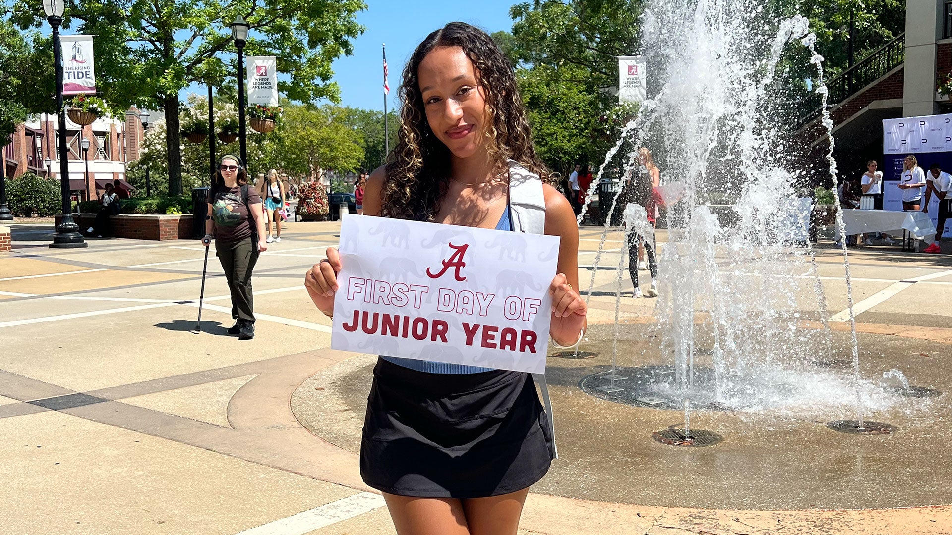 Ciara at the student center fountain holding a sign that reads "First Day of Junior Year"