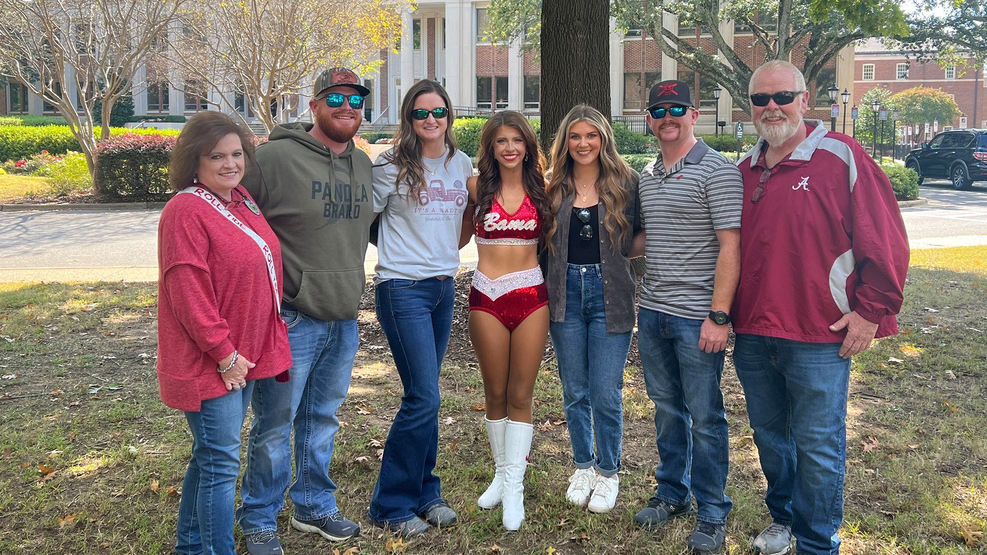 Anna Grace in Crimsonette uniform posing with family on campus