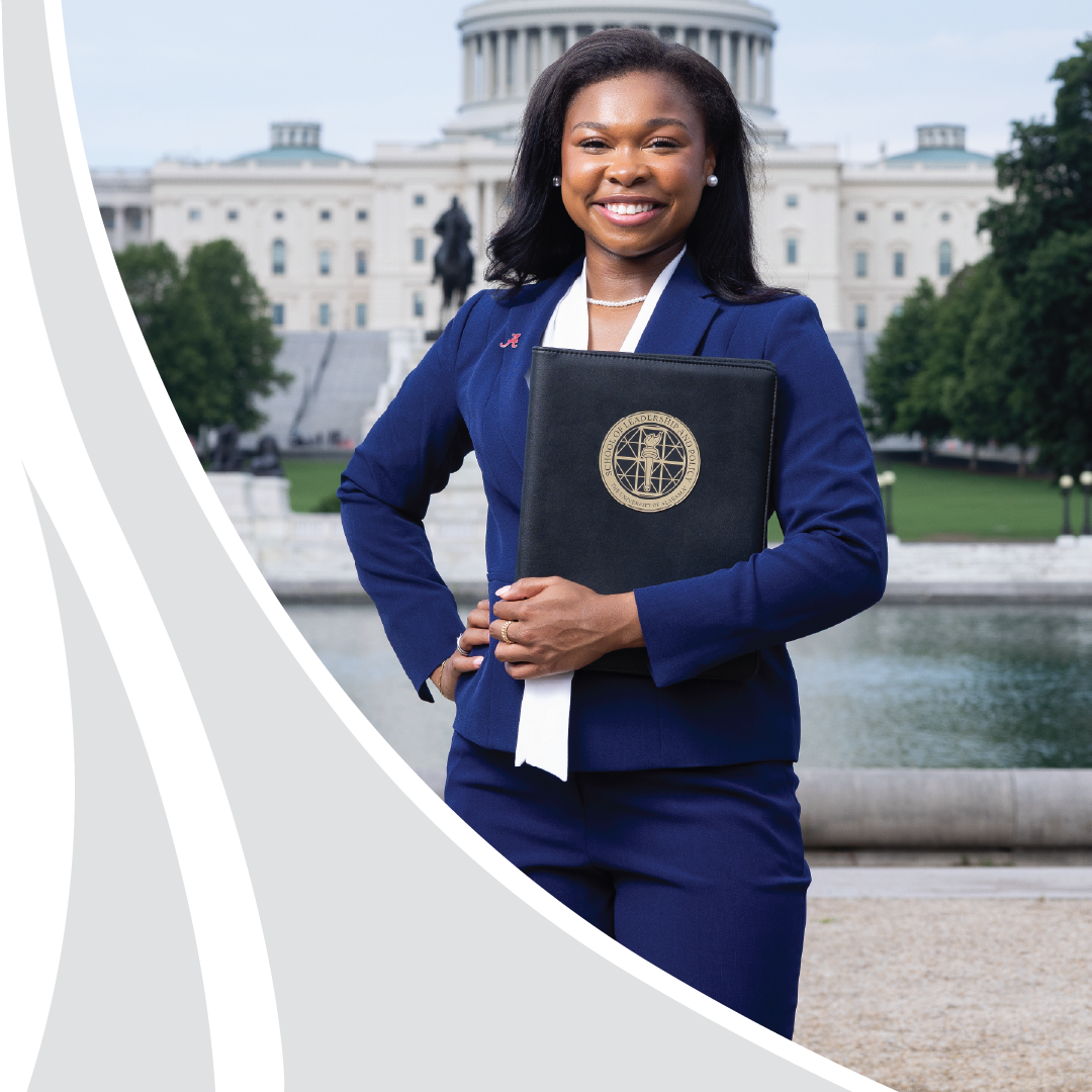 A student in a navy suit holds a School of Leadership and Policy portfolio in front of the U.S. Capitol