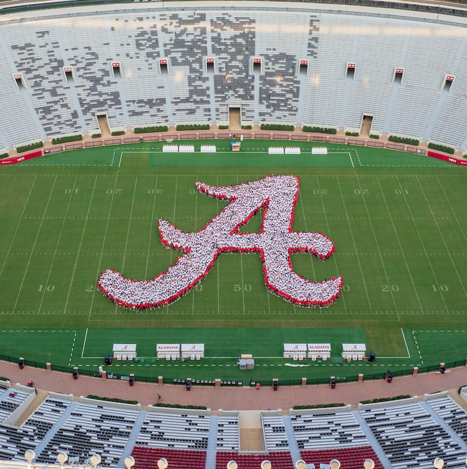 Aerial view of students on the Bryant-Denny Stadium field forming a giant script A