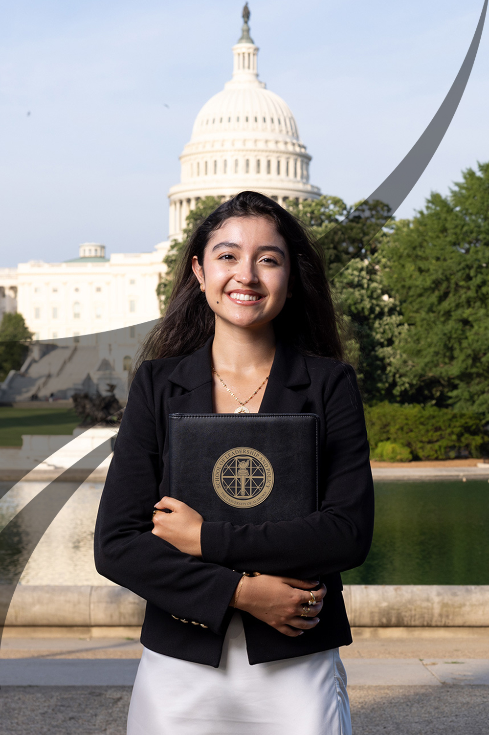 A student in a black blazer holds a School of Leadership and Policy portfolio by the Capitol reflecting pool