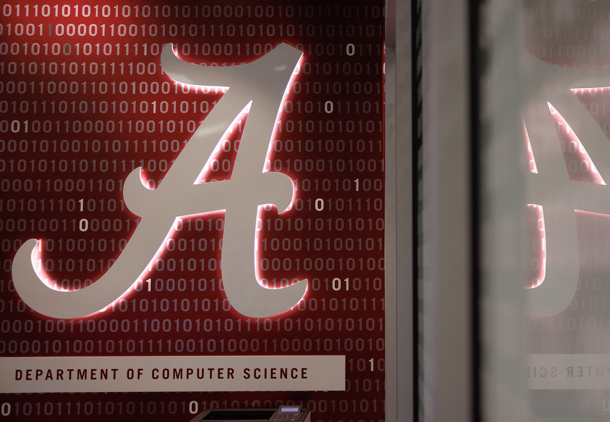 An illuminated script A on a crimson wall of binary digits, labeled Department of Computer Science